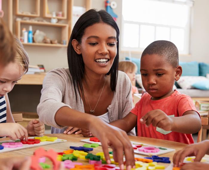 female teacher helping young students